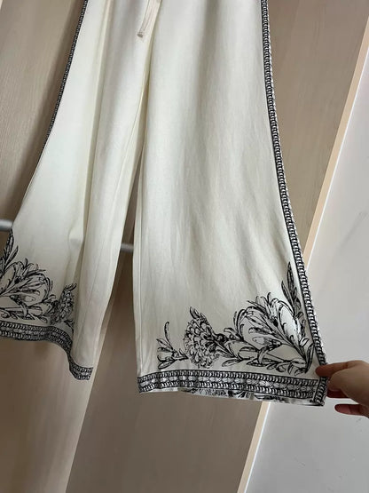 Floral-border wide-leg trousers — styled front view